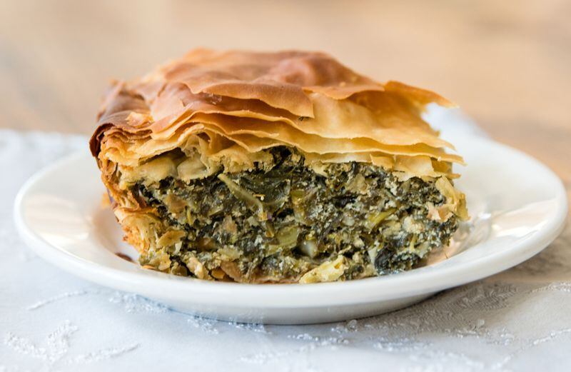  A hearty piece of spanakopita, the Greek phyllo pie made with a Southern twist: collard greens and kale have been substituted for the spinach. CONTRIBUTED BY HENRI HOLLIS