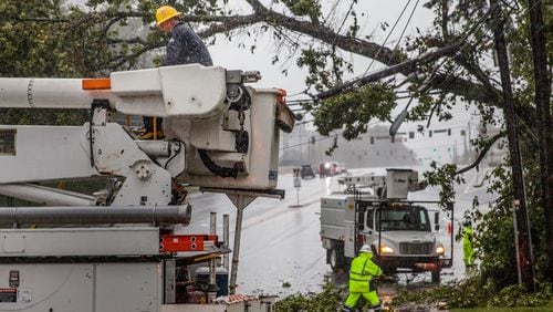 Crews work to clear a tree that fell on power lines on Hammond Drive, Monday, Sept. 11, 2017, in Sandy Springs, Ga.  BRANDEN CAMP/SPECIAL