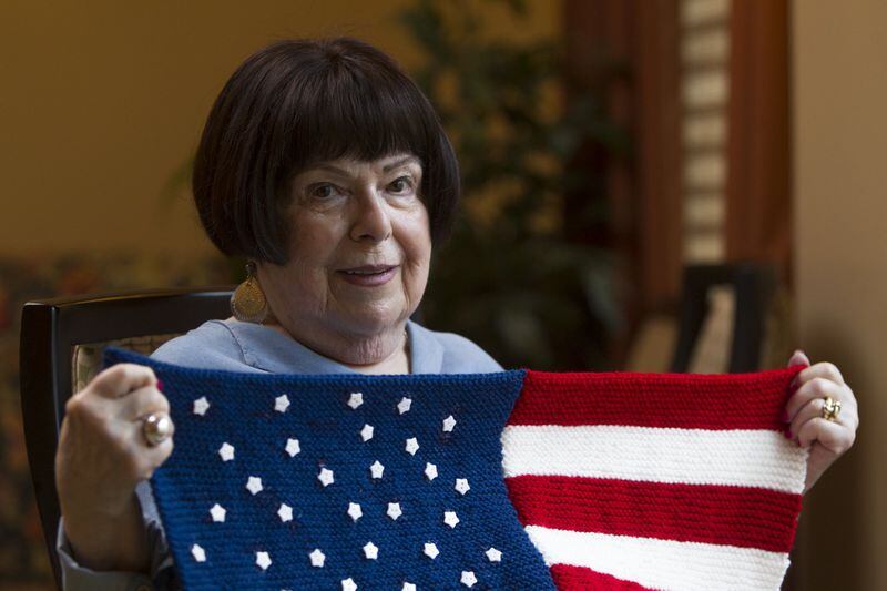 Olive Ellner, 90, poses with an American flag lap quilt that she knitted at Huntcliff Summit, an independent living facility in Sandy Springs. When she sent off her first finished American flag quilt, she said it caused such an uproar at the VA hospital that she thought to recruit others to join her cause. CASEY SYKES / CASEY.SYKES@AJC.COM