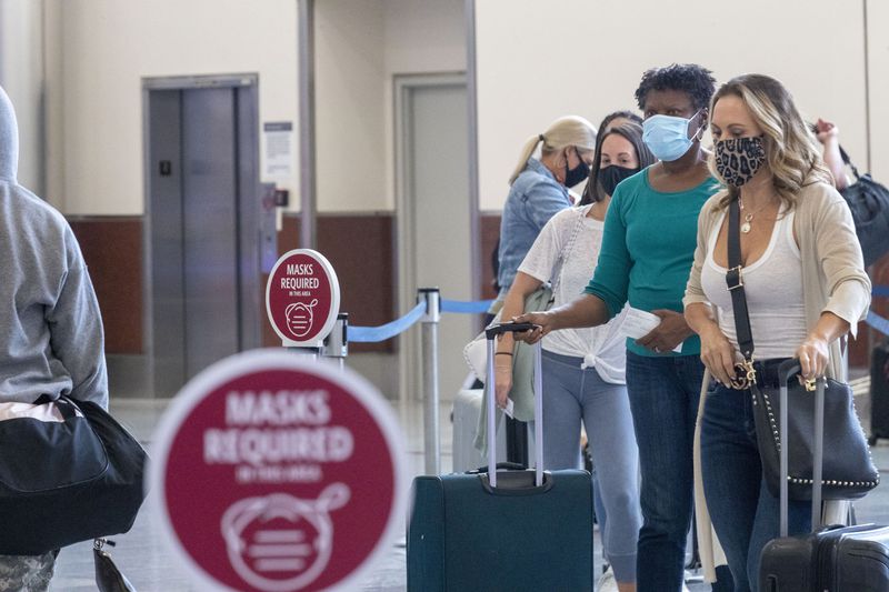 Delta Air Lines customers wear masks as they wait to be served at the ticker counter in the domestic terminal at Hartsfield-Jackson Atlanta International Airport, Friday, September 4, 2020. (Alyssa Pointer / Atlanta Journal-Constitution)