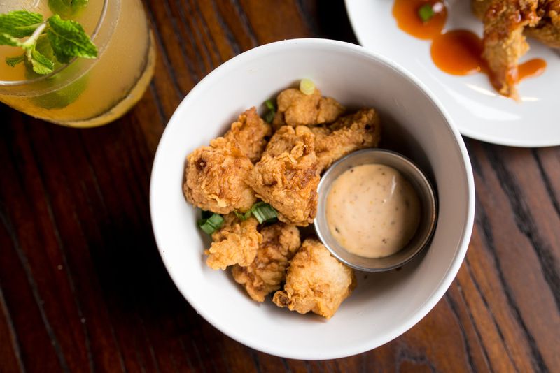 The Shawk Bites — tender shark meat seasoned, lightly battered and fried golden — at Virgil’s Gullah Kitchen and Bar are served with a remoulade for dipping. (Mia Yakel for The Atlanta Journal-Constitution) 