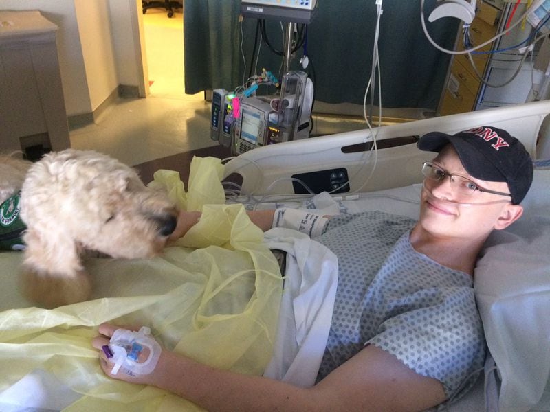 Michael Torpy in the hospital, chillin’ with his service dog, Tidings.