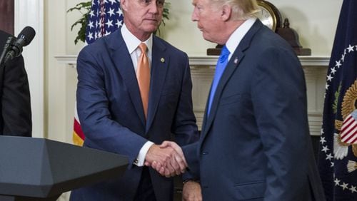 WASHINGTON, DC - AUGUST 2: (AFP OUT) U.S. President Donald Trump shakes hands with Sen. David Perdue (R-GA) during an announcement on the introduction of the Reforming American Immigration for a Strong Economy (RAISE) Act in the Roosevelt Room at the White House on August 2, 2017 in Washington, DC. The act aims to overhaul U.S. immigration by moving towards a "merit-based" system.  (Photo by Zach Gibson - Pool/Getty Images)