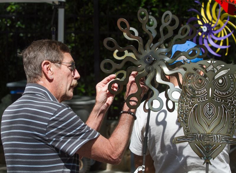 Rob Lee looks over yard art for sale during the 47th Inman Park Spring Festival on Sunday, April 29, 2018.