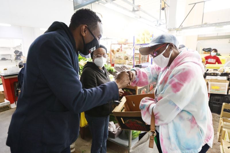 Atlanta mayoral candidate Andre Dickens fist bumps a customer at the Municipal Market. Saturday, November 20, 2021. Miguel Martinez for The Atlanta Journal-Constitution 