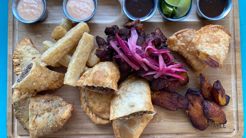 A tabla from Raul's Latin Kitchen brings a selection of Puerto Rican appetizers, including empanadas, carne frita and maduros. (Ligaya Figueras / ligaya.figueras@ajc.com)
