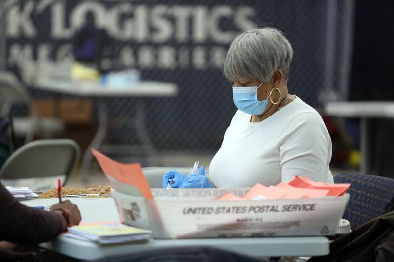 A woman sorts absentee ballots at the DeKalb County Elections Office in Decatur on Jan. 6, 2021. 