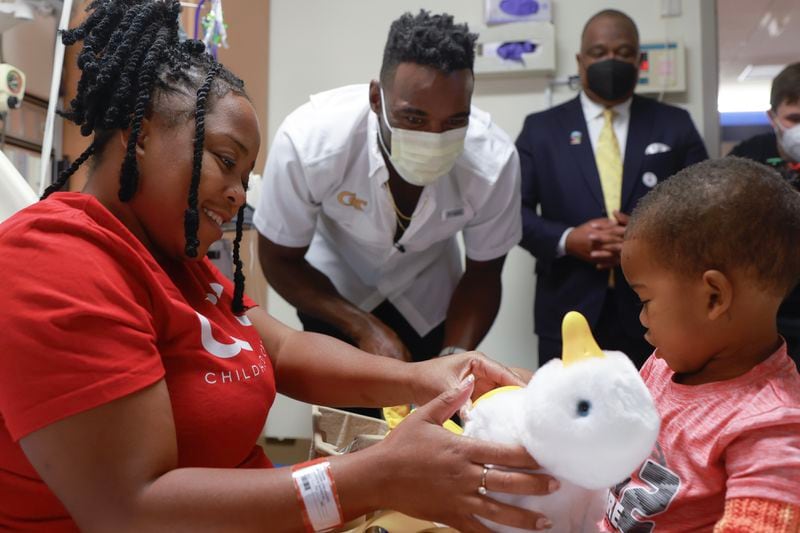 NFL Hall of Famer and former Georgia Tech player Calvin Johnson presents Grayson Simms, 3, and his mother Hikendria with an Aflac duck while visiting the Cancer Center at Egleston Children’s Hospital in Atlanta on Friday, September 1, 2023. Some of the ducks the children received are robotic and specially designed to comfort children with cancer or blood disorders.” (Natrice Miller/ Natrice.miller@ajc.com) 