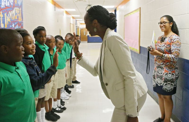 Aug. 3, 2015 - Atlanta - Principal Gilberte Pascal high fives students as they tour the school and learn procedures. Monday was the first day of school at the new Kindezi Schools campus in Atlanta. The charter school startup is taking the place of charter school that was shuttered this summer after five years of failure. The new operator, who met with success at the first Kindezi campus across town, has high hopes for this new elementary school, near a homeless shelter and a trashed park in Atlanta's Old Fourth Ward. BOB ANDRES / BANDRES@AJC.COM