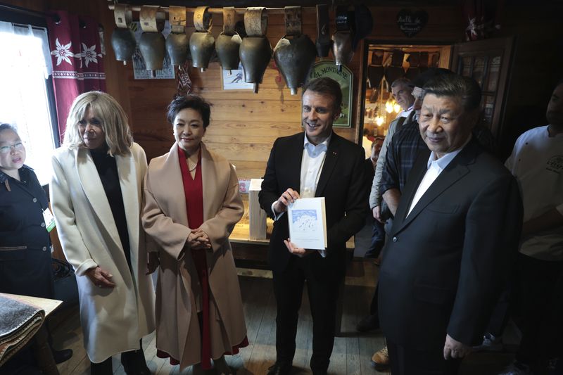 Chinese President Xi Jinping, right, and his wife Peng Liyuan, second left, French President Emmanuel Macron and his wife Brigitte Macron, left, pose in a restaurant, Tuesday, May 7, 2024 at the Tourmalet pass, in the Pyrenees mountains. French president is hosting China's leader at a remote mountain pass in the Pyrenees for private meetings, after a high-stakes state visit in Paris dominated by trade disputes and Russia's war in Ukraine. French President Emmanuel Macron made a point of inviting Chinese President Xi Jinping to the Tourmalet Pass near the Spanish border, where Macron spent time as a child visiting his grandmother. (AP Photo/Aurelien Morissard, Pool)