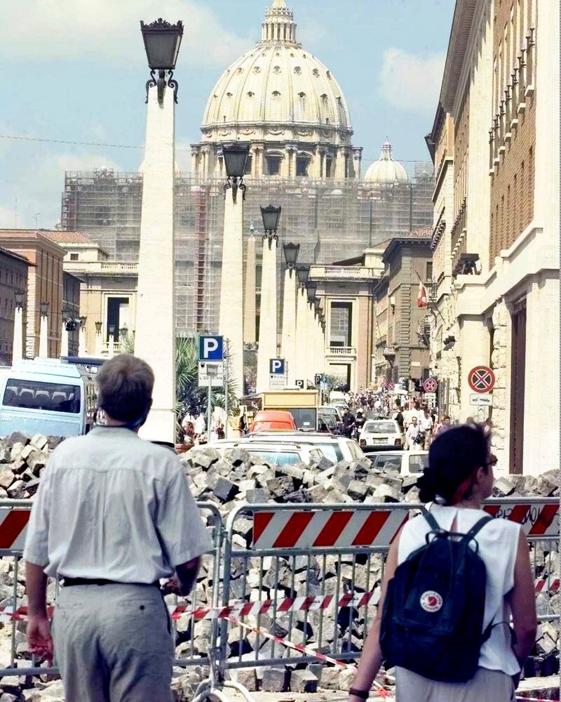 Tourists approaching the Vatican's St. Peter's Basilica Saturday, July 11, 1998, walk through street works. The Vatican crosses a key milestone Thursday, May 9, 2024, in the run-up to its 2025 Jubilee with the promulgation of the official decree establishing the Holy Year: a once-every-quarter-century event that is expected to bring some 32 million pilgrims to Rome and has already brought months of headaches to Romans. (AP Photo/Massimo Sambucetti)