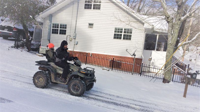 Russ Stevenson drives one of his sons, Tyler, down a hill in snowy Blue Ridge, where the family went sledding Saturday. (Craig Schneider / cschneider@ajc.com)