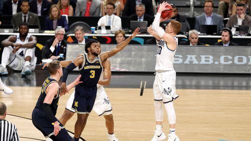 Donte DiVincenzo of the Villanova Wildcats attempts a jump shot against Zavier Simpson of the Michigan Wolverines in the second half during the 2018 NCAA Men's Final Four National Championship game at the Alamodome on April 2, 2018 in San Antonio, Texas.  (Photo by Chris Covatta/Getty Images)
