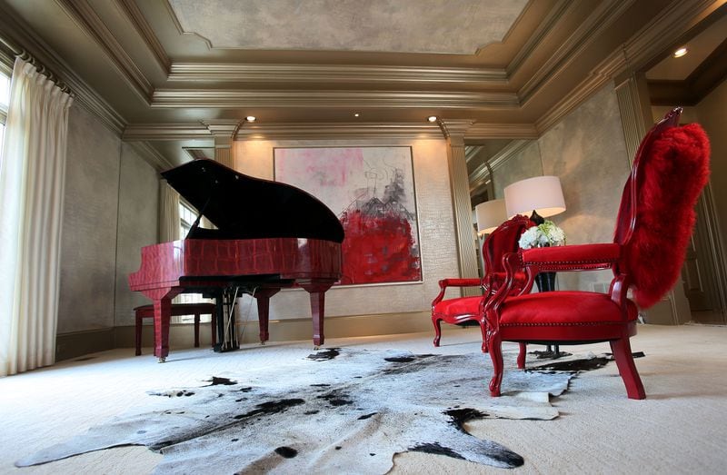 Burruss' piano room features red chairs, a crocodile-print piano and a custom painting.