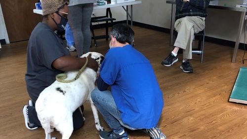 Volunteers and clients are pictured at a PALS  (Pets Are Loving Support) shot clinic. Everyone pictured is wearing a face mask.