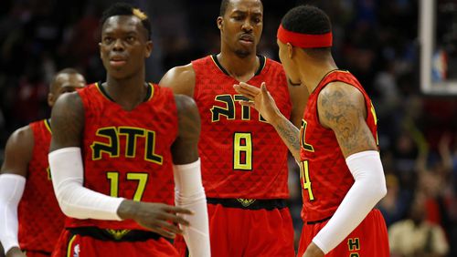 Atlanta Hawks center Dwight Howard (8) reacts with teammates guard Dennis Schroder (17) and forward Kent Bazemore (24) after his dunk in the second half of an NBA basketball game against the New York Knicks on Sunday, Jan. 29, 2017, in Atlanta. The Hawks won the game in the fourth overtime 142-139. (AP Photo/Todd Kirkland)