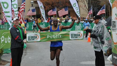 Abraham Kogo, of Hebron, Ky., wins first place in the Publix Georgia Marathon with a time of 2:33:21 as he crosses the finish line at Centennial Olympic Park Sunday, March 23, 2014, in Atlanta. David Tulis / AJC Special