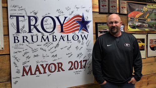 City of Cumming Mayor-elect Troy Brumbalow at his home with one of his campaign signs signed by friends and volunteers on election night as they celebrated his upset over long-time incumbent H. Ford Gravitt. Marty Farrell for the AJC