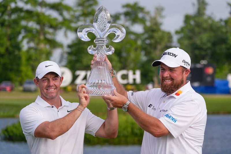 Rory McIlroy, of Northern Ireland, and teammate Shane Lowry, of Ireland, right hold up their trophy after winning the PGA Zurich Classic golf tournament at TPC Louisiana in Avondale, La., Sunday, April 28, 2024. (AP Photo/Gerald Herbert)