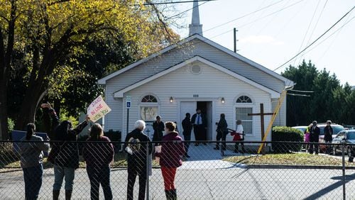 Members from Hall County Democrats and Indivisible Lumpkin hold signs of support across the street from Bethel African Methodist Episcopal Church in Gainesville, Ga Sunday, Nov 24, 2019.