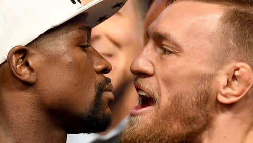Boxer Floyd Mayweather Jr. (left) and UFC lightweight champion Conor McGregor face off during their official weigh-in at T-Mobile Arena .