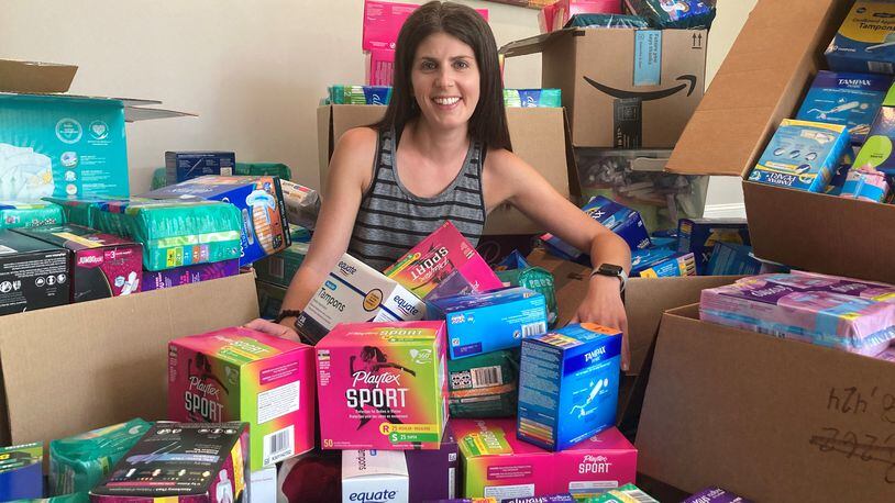 Jessica Sacks, co-chair of Project Dignity, shows off thousands of boxes of menstrual products she and volunteers collected. Courtesy of Jessica Sacks