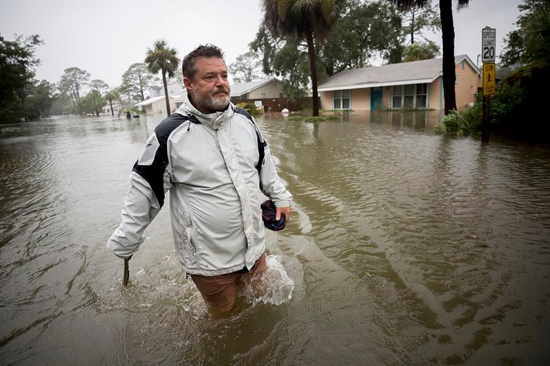 Joey Spalding walks back to his truck down the street where he lives, Monday, Sept., 11, 2017, on Tybee Island, Ga. Spalding just finished repairing his house from nine inches of water after Hurricane Matthew past the island last year. He said the Tropical Storm Irma brought three feet of storm surge into his living room today. (AP Photo/Stephen B. Morton)
