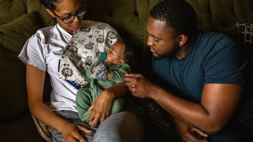 Christiana Layne, 26, left, and Danny Rollins, 32, are focused on their newborn, Braylen Rollins, at their home. (Francine Orr/Los Angeles Times/TNS)
