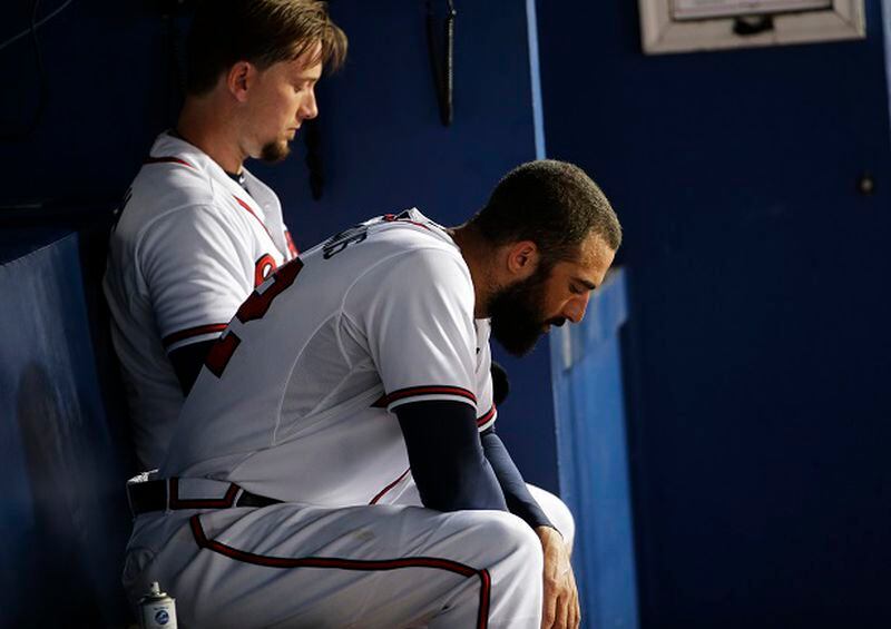 Atlanta Braves' Nick Markakis, right, sits in the dugout with teammate Chris Johnson during the sixth inning of a baseball game against the San Francisco Giants on Tuesday, Aug. 4, 2015, in Atlanta. The Giants won 8-3. (AP Photo/David Goldman)