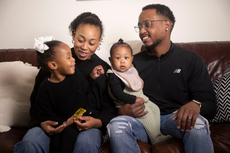 Daizha Rioland, left, and Kenneth Rioland hold daughters, Alani, 2, and 9-month-old Izabella, as they pose for photos at their home on Saturday, Feb. 17, 2024, in Dallas. The family has struggled to find quality child care for their first daughter. (Juan Figueroa/The Dallas Morning News via AP)