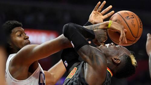 Atlanta Hawks guard Dennis Schroder, right, has his shot blocked by Los Angeles Clippers guard Tyrone Wallace during the first half of a basketball game, Monday, Jan. 8, 2018, in Los Angeles. (AP Photo/Mark J. Terrill)