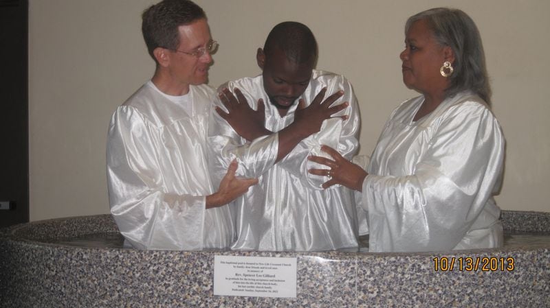 Co-pastors Tim Rodgers and Catherine Gilliard prepare to baptize a member at New Life Covenant Church. They believe the church should play a role in healing the racial divide in our nation. Contributed