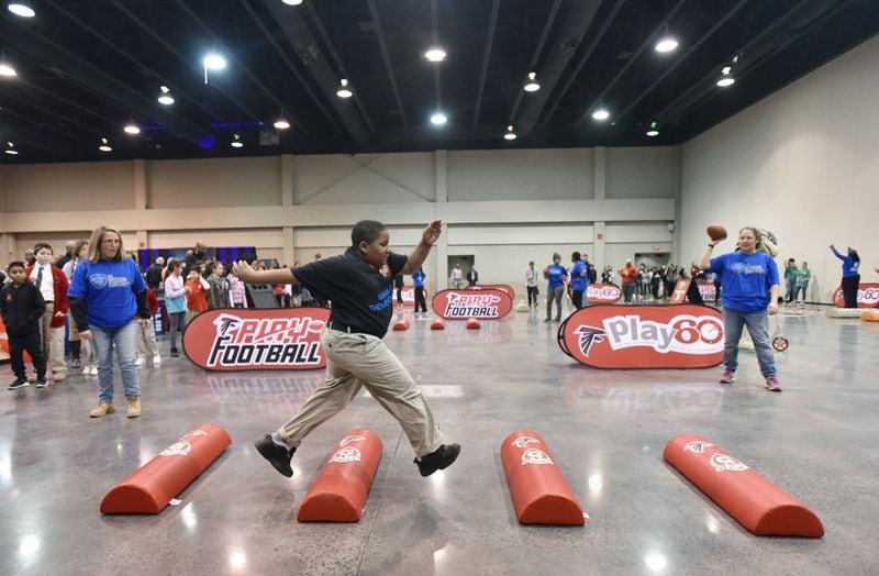 Students enjoyed indoor games during the NFL’s Super Kids-Super Sharing project at the Infinite Energy Forum in Duluth. HYOSUB SHIN / HSHIN@AJC.COM