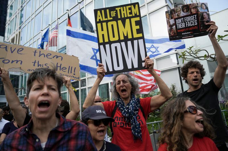 Families and supporters of Israeli hostages held by Hamas in Gaza hold banners and flags during a protest calling for their return, outside a meeting between U.S. Secretary of State Antony Blinken and families of hostages in Tel Aviv, Israel, Wednesday, May 1, 2024. (AP Photo/Oded Balilty)