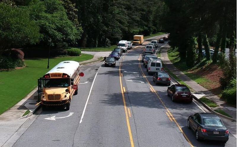 Fulton County Schools bus stops on Powers Ferry Road in Sandy Springs on Wednesday, May 23, 2018. A phrase added to a 15-page bill approved late in the Georgia legislative session last year has caused panic among officials responsible for getting children to and from school safely. HYOSUB SHIN / HSHIN@AJC.COM