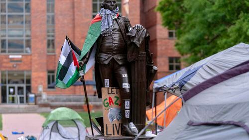 A statue of George Washington draped in a Palestinian flag and a keffiyeh is seen at George Washington University as students demonstrate on campus during a pro-Palestinian protest over the Israel-Hamas war on Friday, April 26, 2024, in Washington. (AP Photo/Jose Luis Magana)