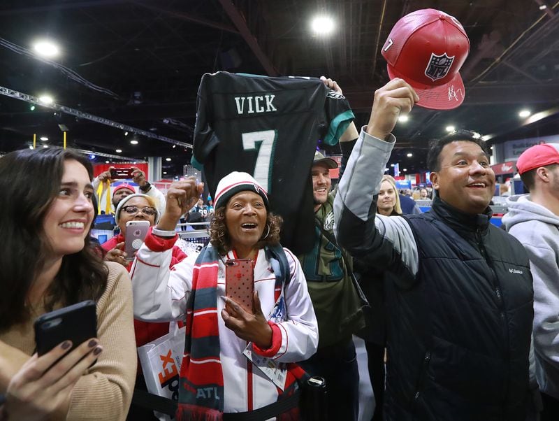 Jan. 31, 2019 Atlanta: Falcons fans cheer former Falcons and Eagles quarterback Michael Vick while he autographs items in the NFL Shop at the Super Bowl Experience on Thursday, Jan. 31, 2019, in Atlanta. Vick has a special edition New Era hat on sale in the NFL Shop.   Curtis Compton/ccompton@ajc.com