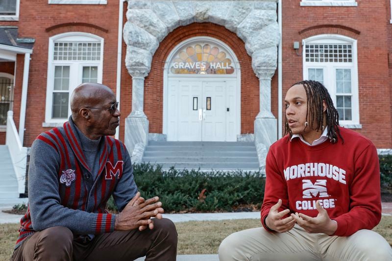 Edwin Moses listens to current Morehouse student and AJC intern Auzzy Byrdsell in front of Graves Hall, the oldest building on campus. Moses says that world events forced his generation to create a strong sense of unity and stability. (Natrice Miller/ Natrice.miller@ajc.com)