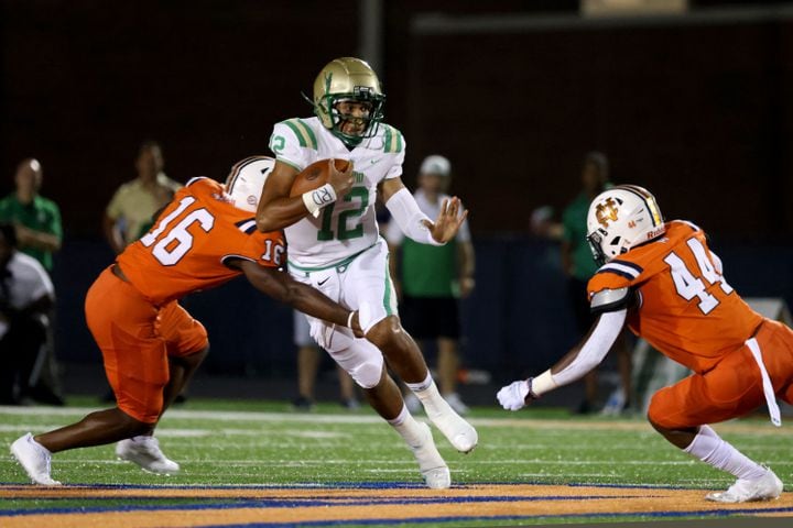 August 20, 2021 - Kennesaw, Ga: Buford quarterback Ashton Daniels (12) runs against North Cobb defenders Kameron Owens (16) and Grayson Hodges (44) during the first half at North Cobb high school Friday, August 20, 2021 in Kennesaw, Ga.. JASON GETZ FOR THE ATLANTA JOURNAL-CONSTITUTION