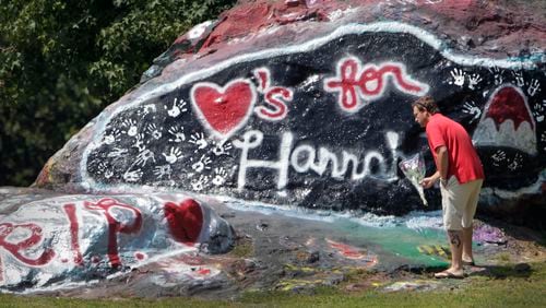 Jason Flanagan, who said he was a neighbor of Hannah Truelove, stopped by the rock to leave a bouquet of flowers in this AJC file photo. Gainesville high students painted a memorial to Hannah Truelove on "the Rock" near campus.