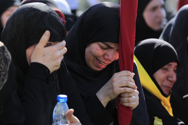Mourners react during the funeral of Ismail Baz, a Hezbollah commander and another fighter who were killed on Tuesday by an Israeli drone strike, in Chehabiyeh village, south Lebanon, Wednesday, April 17, 2024. The Israeli military said Baz served as a senior and veteran official in several positions of Hezbollah's military wing. (AP Photo/Mohammed Zaatari)