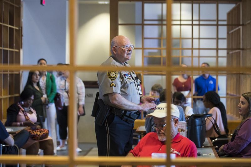 On a recent Thursday evening, Gwinnett County Sheriff Officer E. Marsden instructs individuals on the nightly procedures as they wait to enter a courtroom at the Gwinnett County Justice Center. Thursdays are designated for debt disputes in small claims court. (ALYSSA POINTER/ALYSSA.POINTER@AJC.COM)