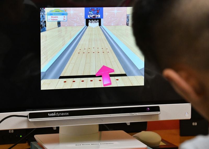 Summer camp participant Brandon, 7, plays a video bowling game using eye tracker technology during a summer camp for children with special needs at Lekotek of Georgia in Tucker on Tuesday, July 12, 2022. (Hyosub Shin / Hyosub.Shin@ajc.com)