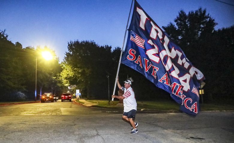 August 24, 2023 Atlanta: Mike Boatman from Evansville, Indiana carries a large Trump flag along Rice Street late Thursday morning, Aug. 24, 2023 where there were more than 100 protestors gathered outside the jail, and they were prepared to wait for hours until the anticipated arrival of former President Donald Trump this afternoon.  (John Spink / John.Spink@ajc.com)


