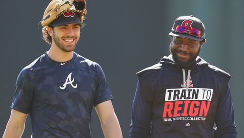 Braves infielders Dansby Swanson and Brandon Phillips share a laugh after their first workout together Friday at Champion Stadium. (Curtis Compton/ccompton@ajc.com)