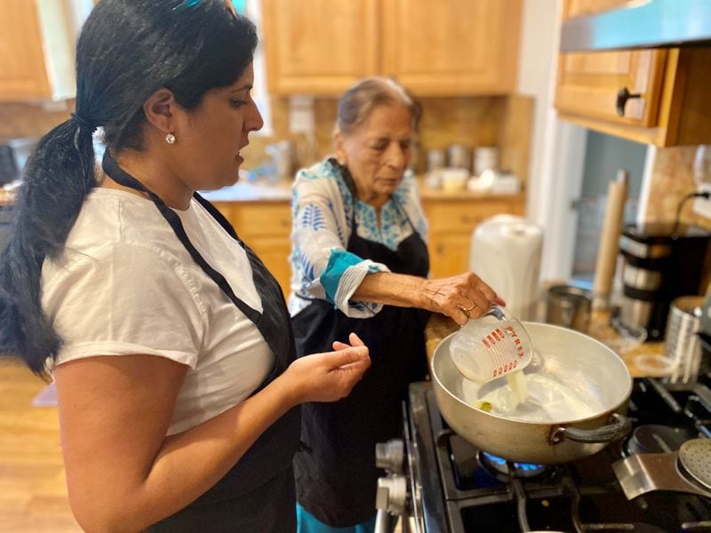 Atlanta chef Archna Becker watches as her nonagenarian grandmother, Nirmala Arneja, stirs up vermicelli kheer, a milky pudding made with thin strands of Indian vermicelli, saffron and chopped nuts. (Wendell Brock for The Atlanta Journal-Constitution)