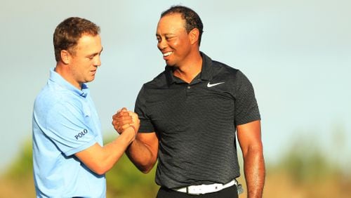 Justin Thomas (left) and Tiger Woods shake hands after finishing on the 18th green during the first round of the Hero World Challenge at Albany, Bahamas on November 30, 2017 in Nassau, Bahamas.  (Photo by Mike Ehrmann/Getty Images)