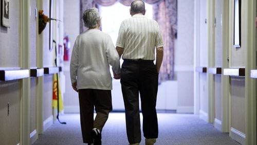 FILE - In this Nov. 6, 2015 file photo, an elderly couple walks down a hall of a nursing home in Easton, Pa. Research released on Tuesday, June 4, 2019 shows fatal falls have nearly tripled in older Americans in recent years, rising to more than 25,000 deaths yearly. (AP Photo/Matt Rourke, File)