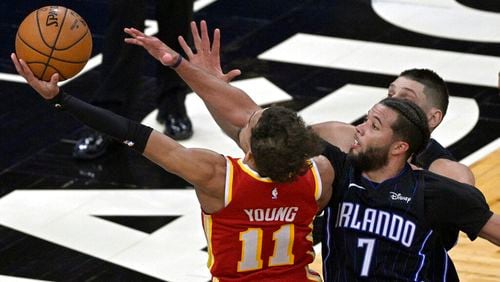 Atlanta Hawks guard Trae Young (11) is fouled by Orlando Magic guard Michael Carter-Williams (7) while going for a shot near the end of the second half of an NBA basketball game, Wednesday, March 3, 2021, in Orlando, Fla. (AP Photo/Phelan M. Ebenhack)