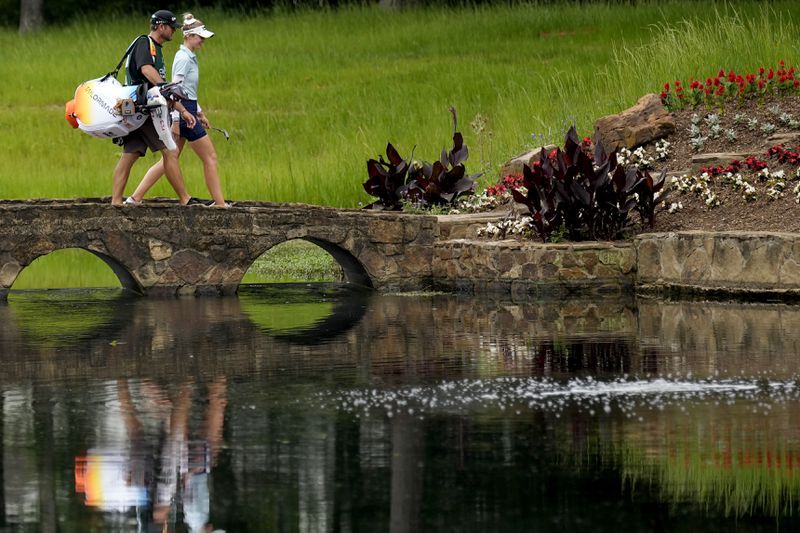 Nelly Korda and he caddie walk across the 15th fairway bridge during the second round of the Chevron Championship LPGA golf tournament Friday, April 19, 2024, at The Club at Carlton Woods, in The Woodlands, Texas. (AP Photo/David J. Phillip)